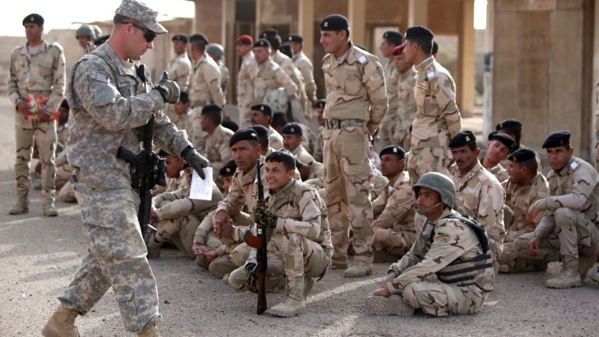 2015-01-07 18:07:26 An American military trainer gives a thumbs up to an Iraqi soldier during an exercise on approaching and clearing buildings at the Taji base complex, which hosts Iraqi and US troops and is located north of the capital Baghdad, on January 7, 2015. Taji is one of an eventual five sites from which the US and allied countries aim to train 5,000 Iraqi military personnel every six to eight weeks for combat against the Islamic State (IS) jihadist group. AFP PHOTO/ AHMAD AL-RUBAYE