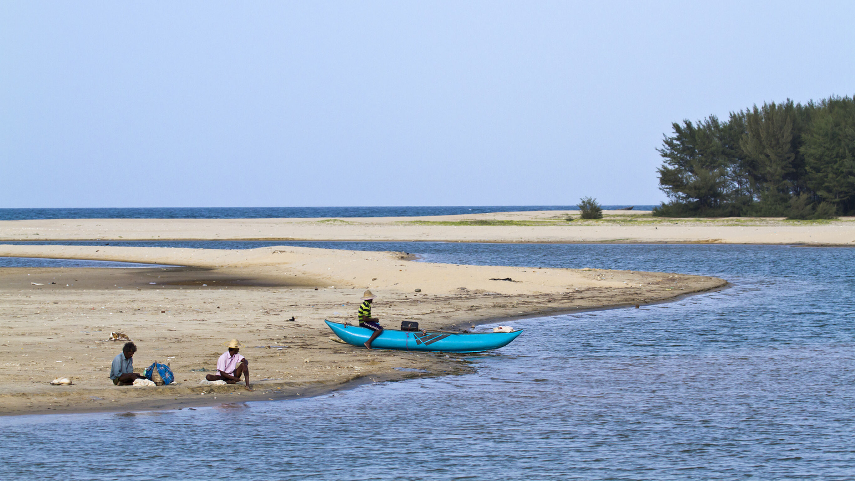 Batticaloa, Sri Lanka - June 25, 2014: Traditional fisherman in Palameenmadu beach, Sri Lanka. They are resting after fishing sitting in sand.