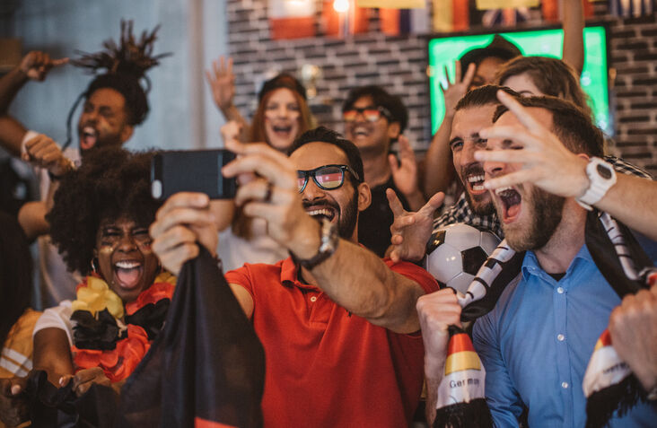 Soccer fans cheering for German team in pub.