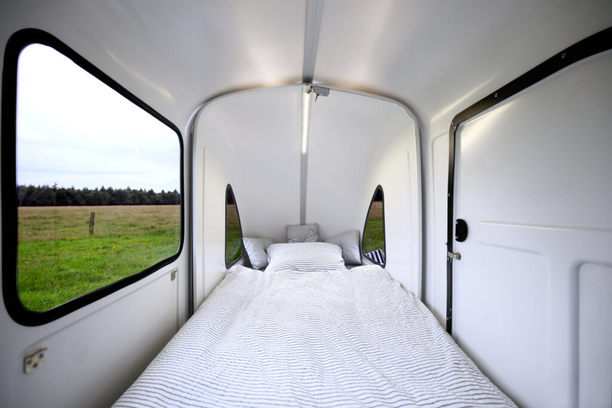 Het interieur met bed van de Wide Path Camper 