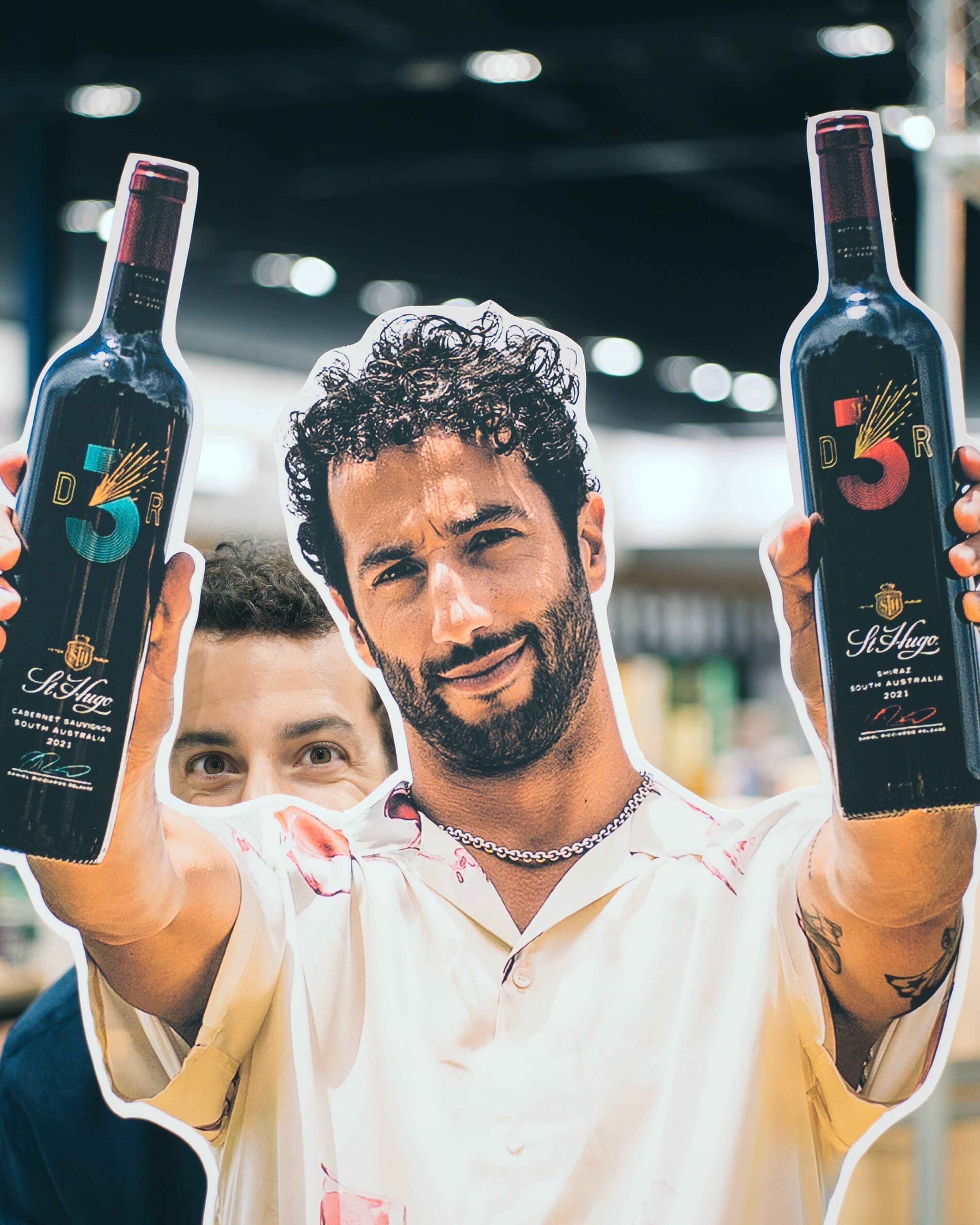 Daniel Ricciardo poseert stiekem achter een levensechte pop van hemzelf in een Australische supermarkt ter promotie van zijn DR3 Wines. 