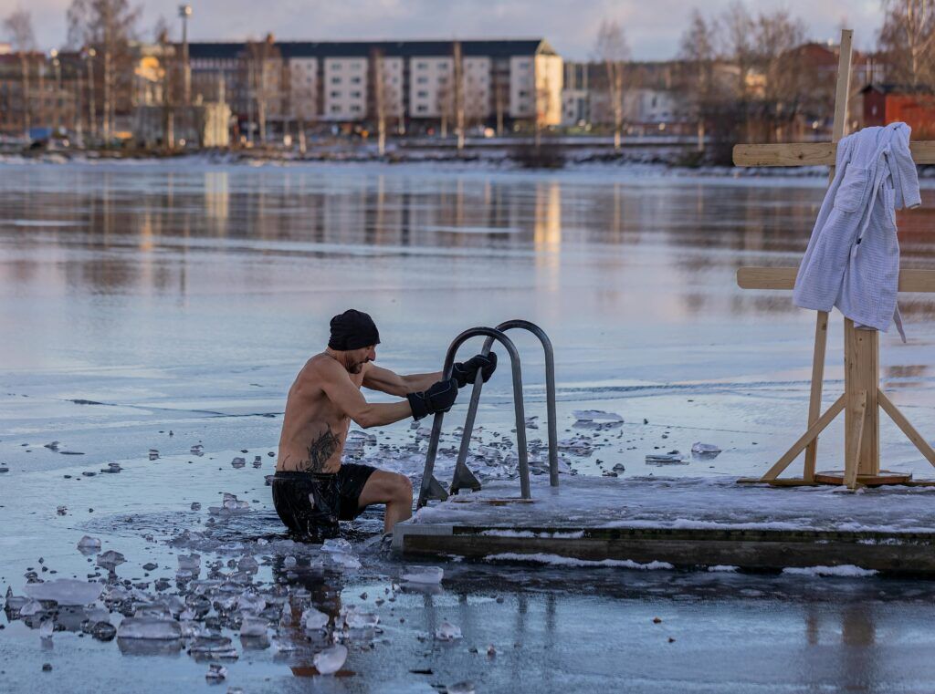 man dijkt in het ijskoude water (een welbekende ijsbad na het sporten)