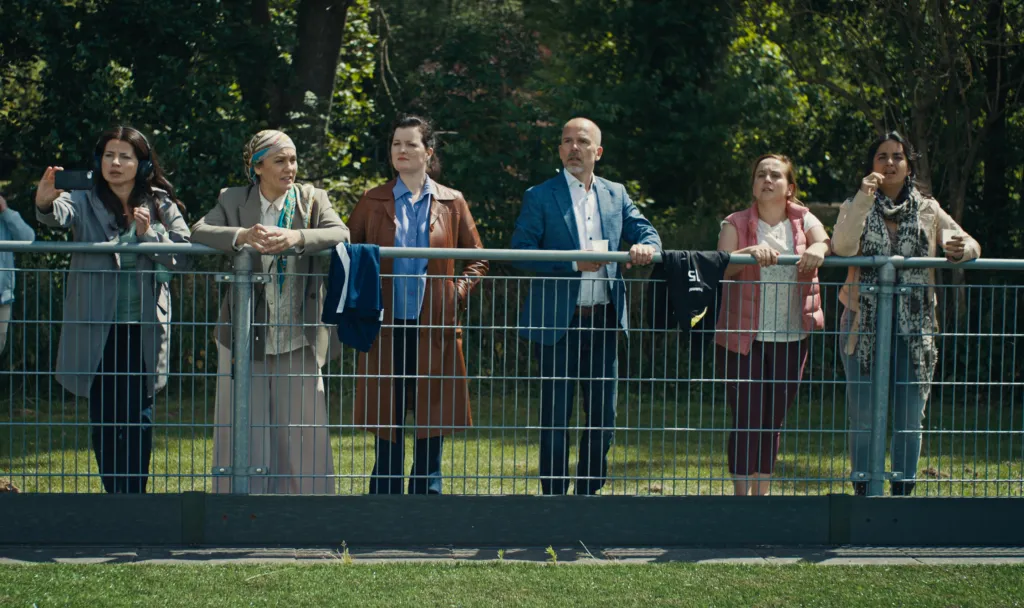Voetbalouders die langs de zijlijn staan in een Netflix-serie