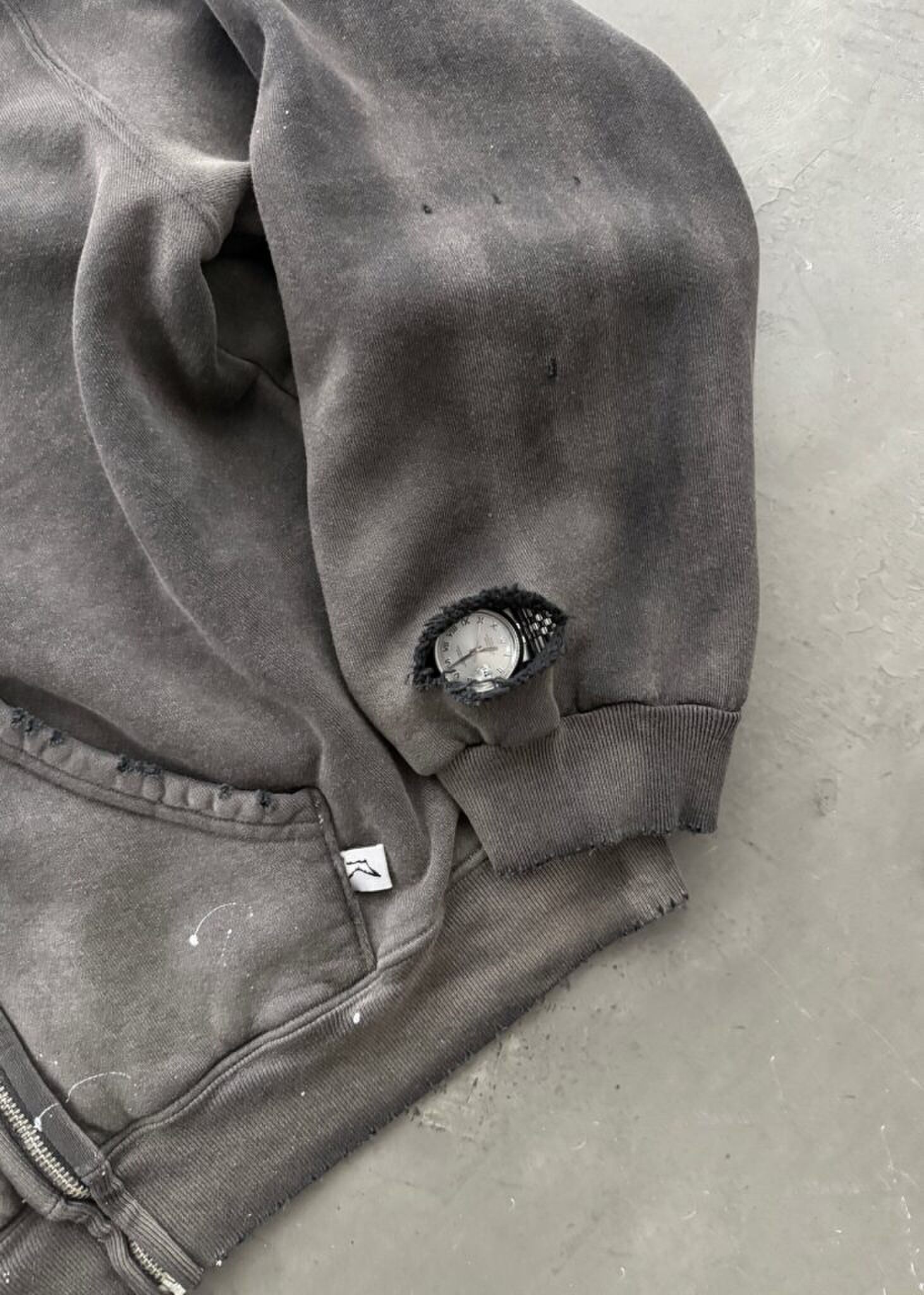 De trui van Akimbo, met een speciaal gat voor je horloge