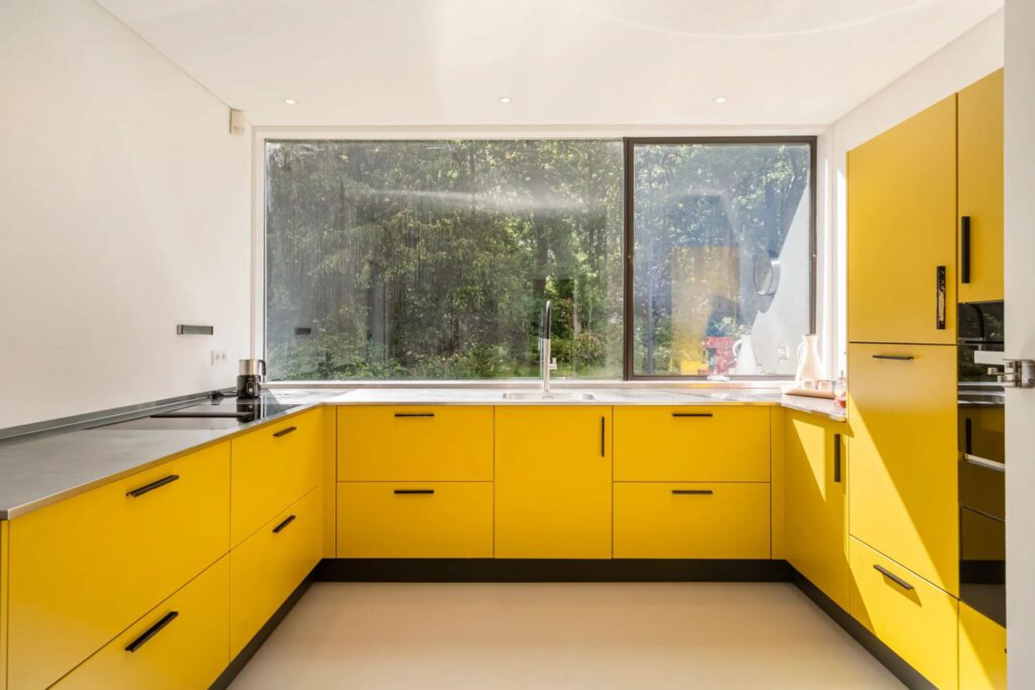 De keuken met gele kastjes.