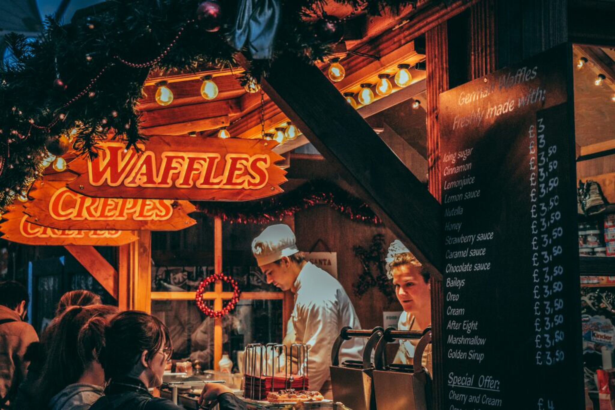 Een houten kraam op een kerstmarkt die wafels en crèpes verkoopt