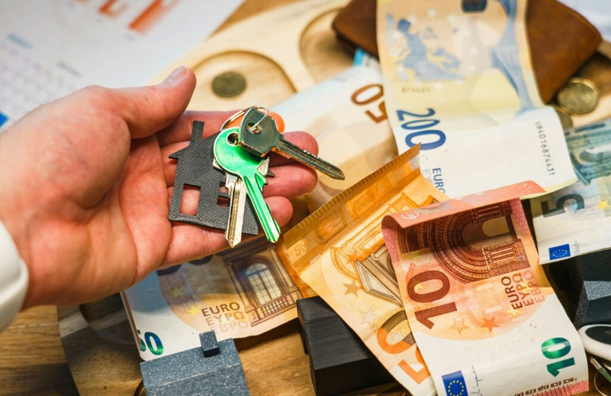 Geld en een huissleutel, elementen die invloed hebben op het vermogen per leeftijdsgroep.