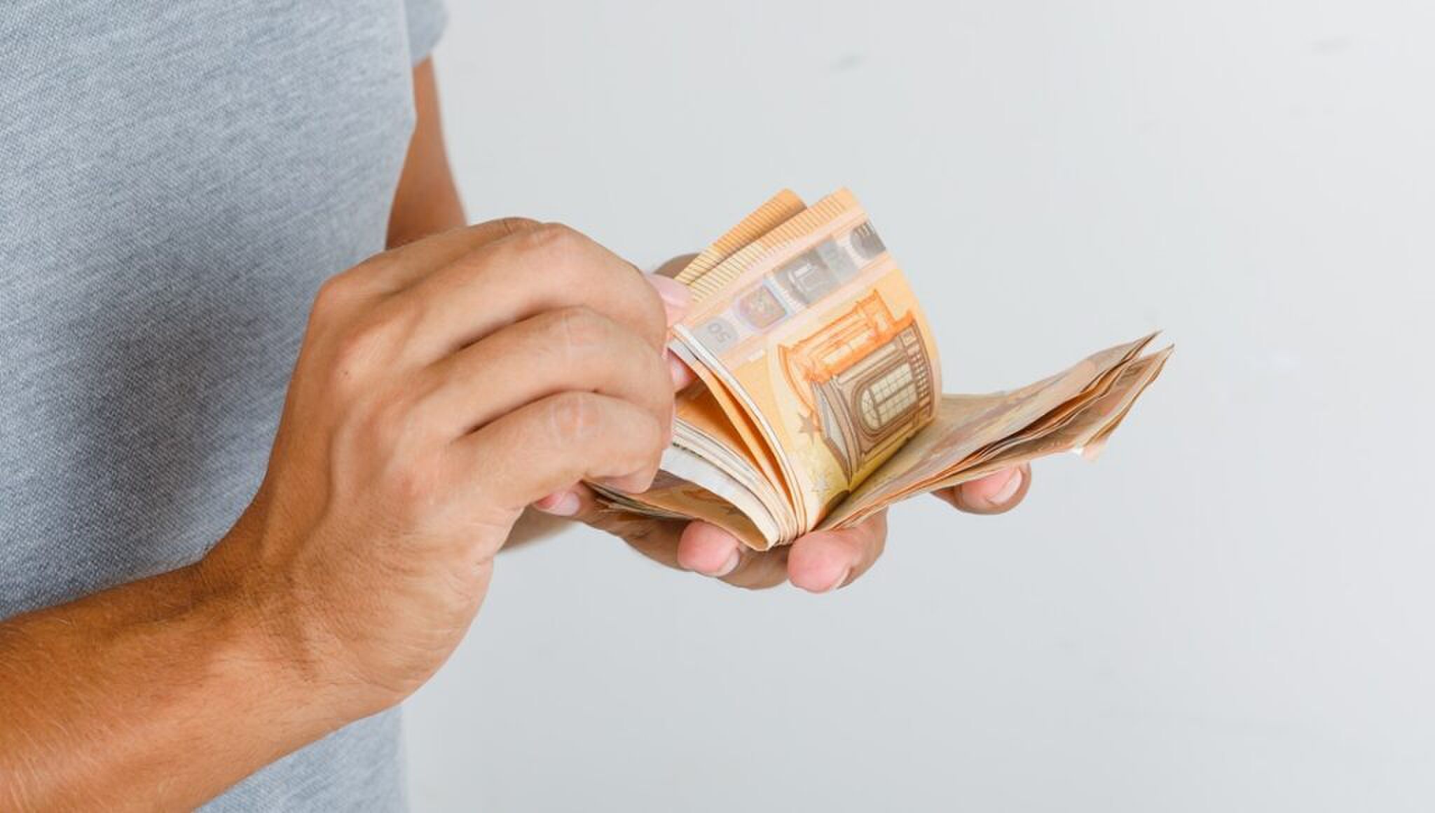 Persoon met briefgeld in handen.
