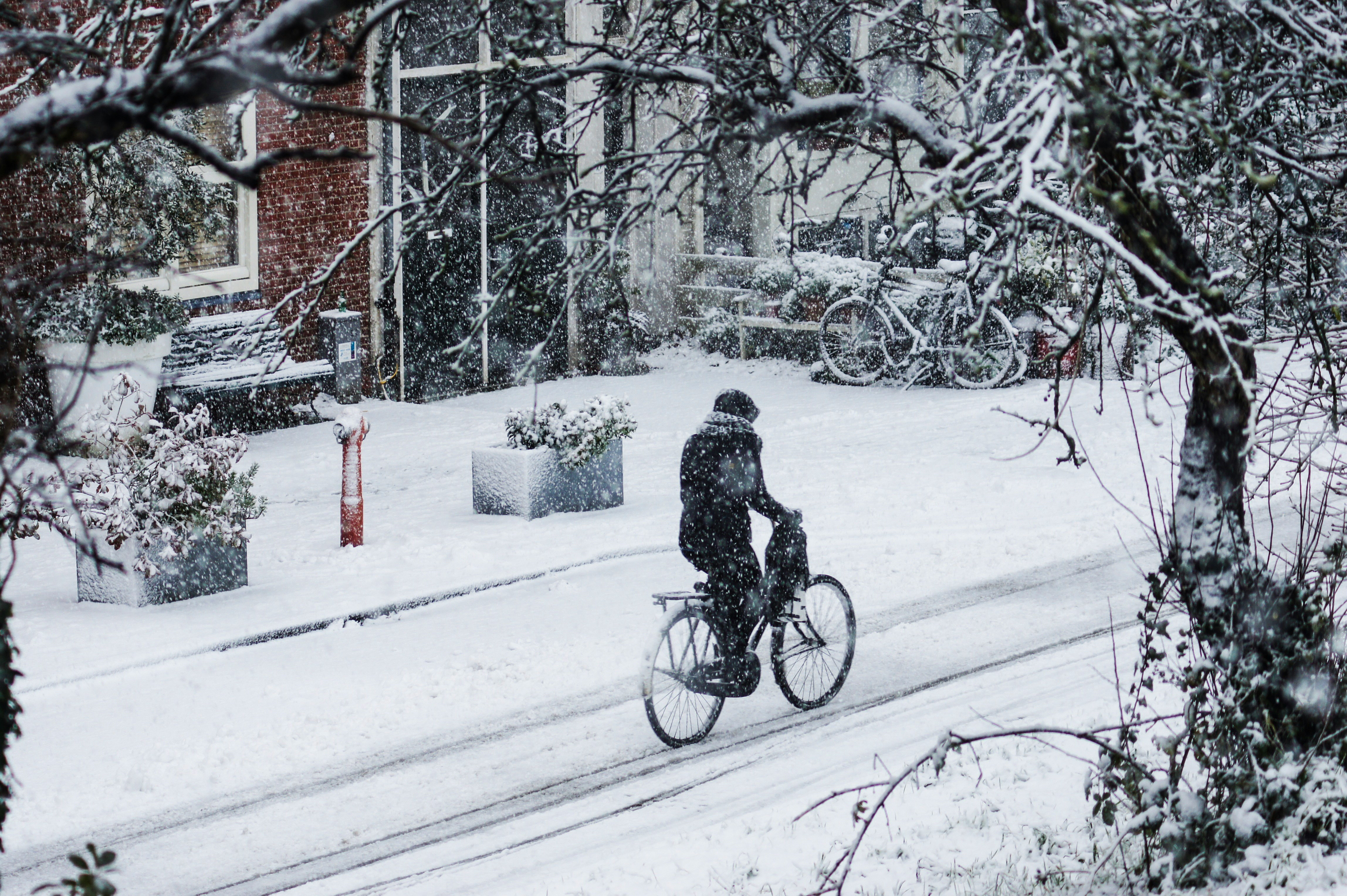 Iemand fietst door een straat vol sneeuw