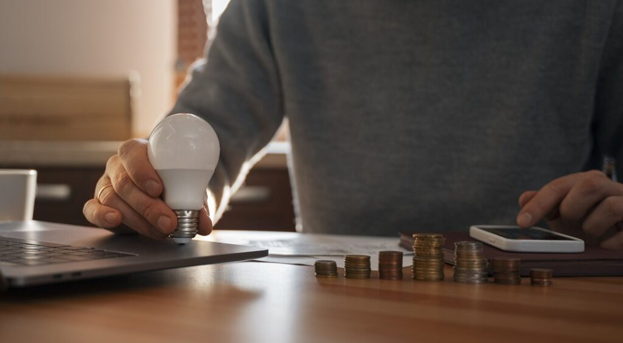 Man die uitrekent hoeveel geld hij kwijt is aan stroom voor zijn lamp.