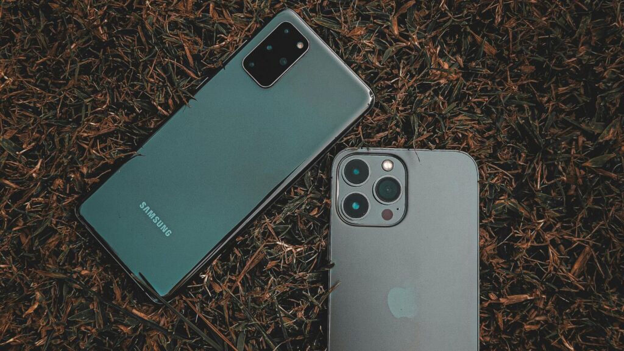 Twee telefoons die liggen op het gras