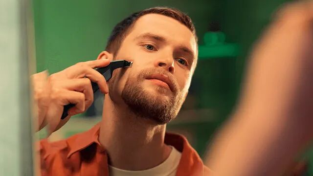 Een man die met een OneBlade zijn baard aan het bijwerken is