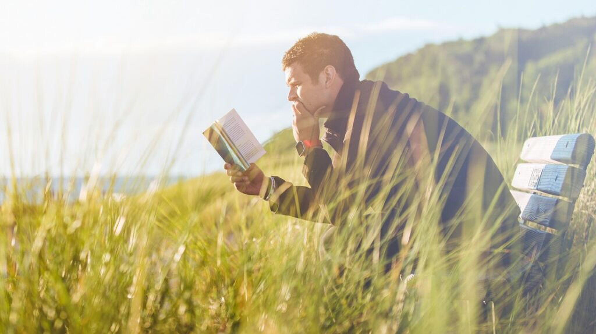 Een man die uit een boek leest.