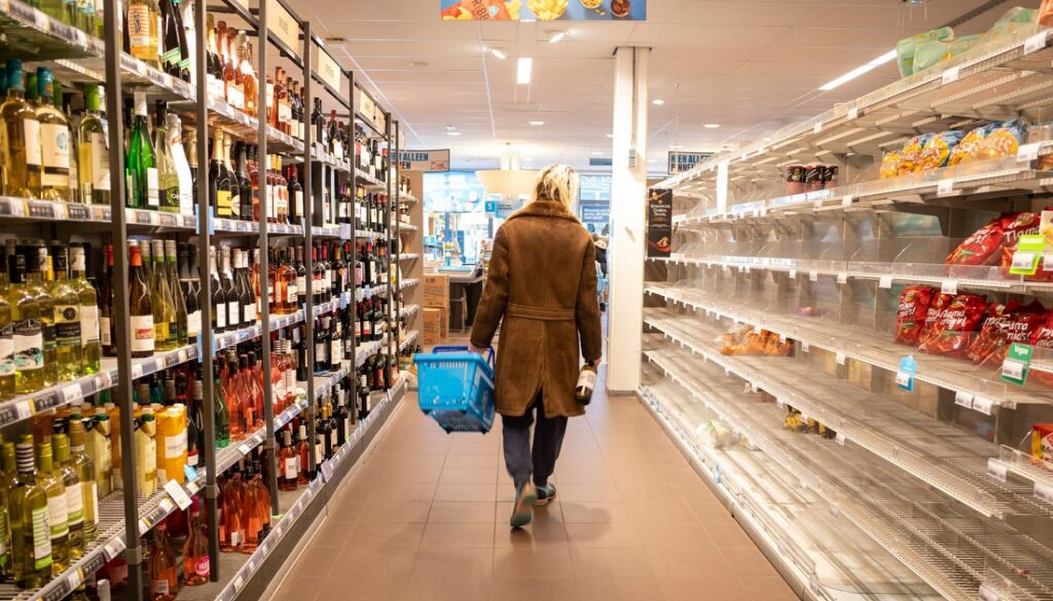 Een vrouw in een gangpad van de supermarkt.