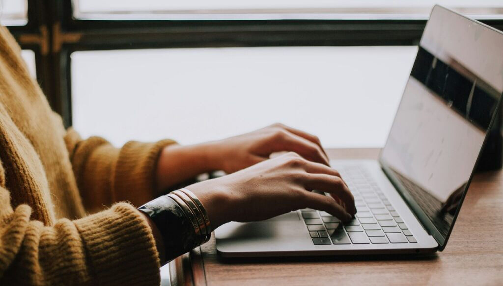 Iemand die werkt achter een laptop.