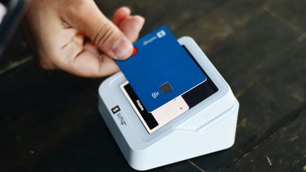 Een man pint voor een aankoop bij een pinautomaat