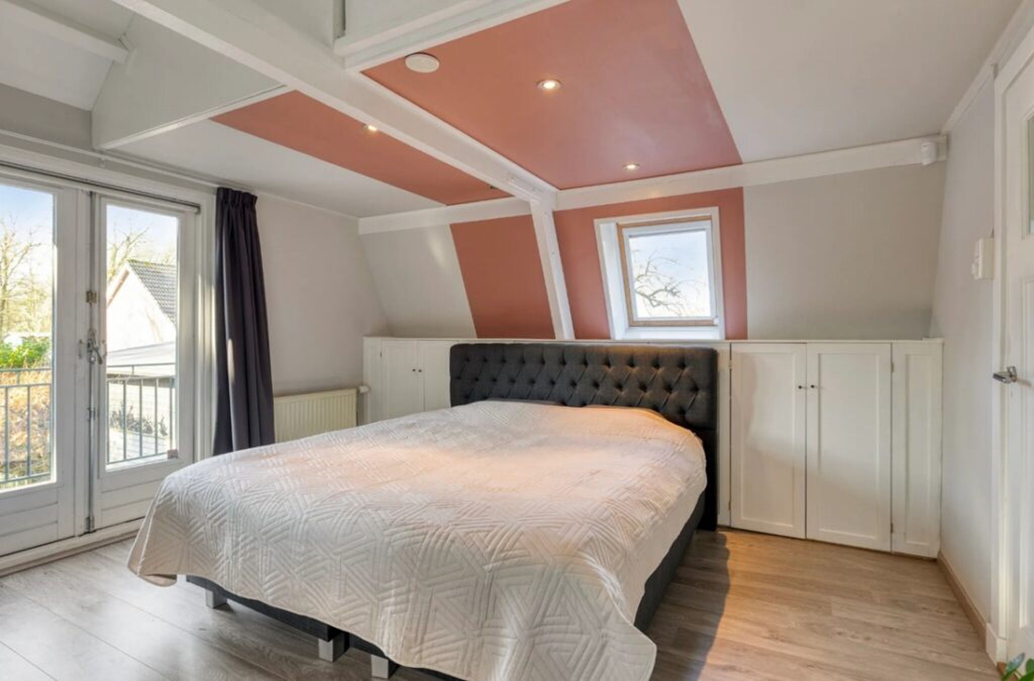 De hoofdslaapkamer met balkon.