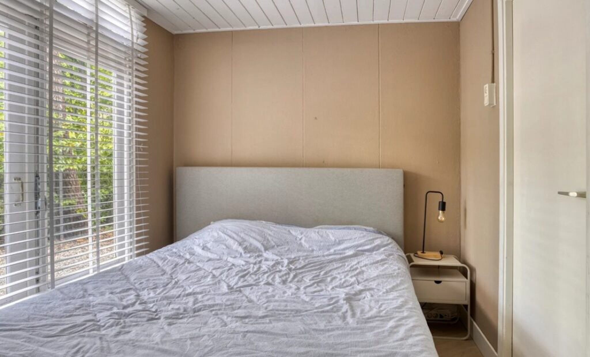 De slaapkamer met uitzicht op de tuin.