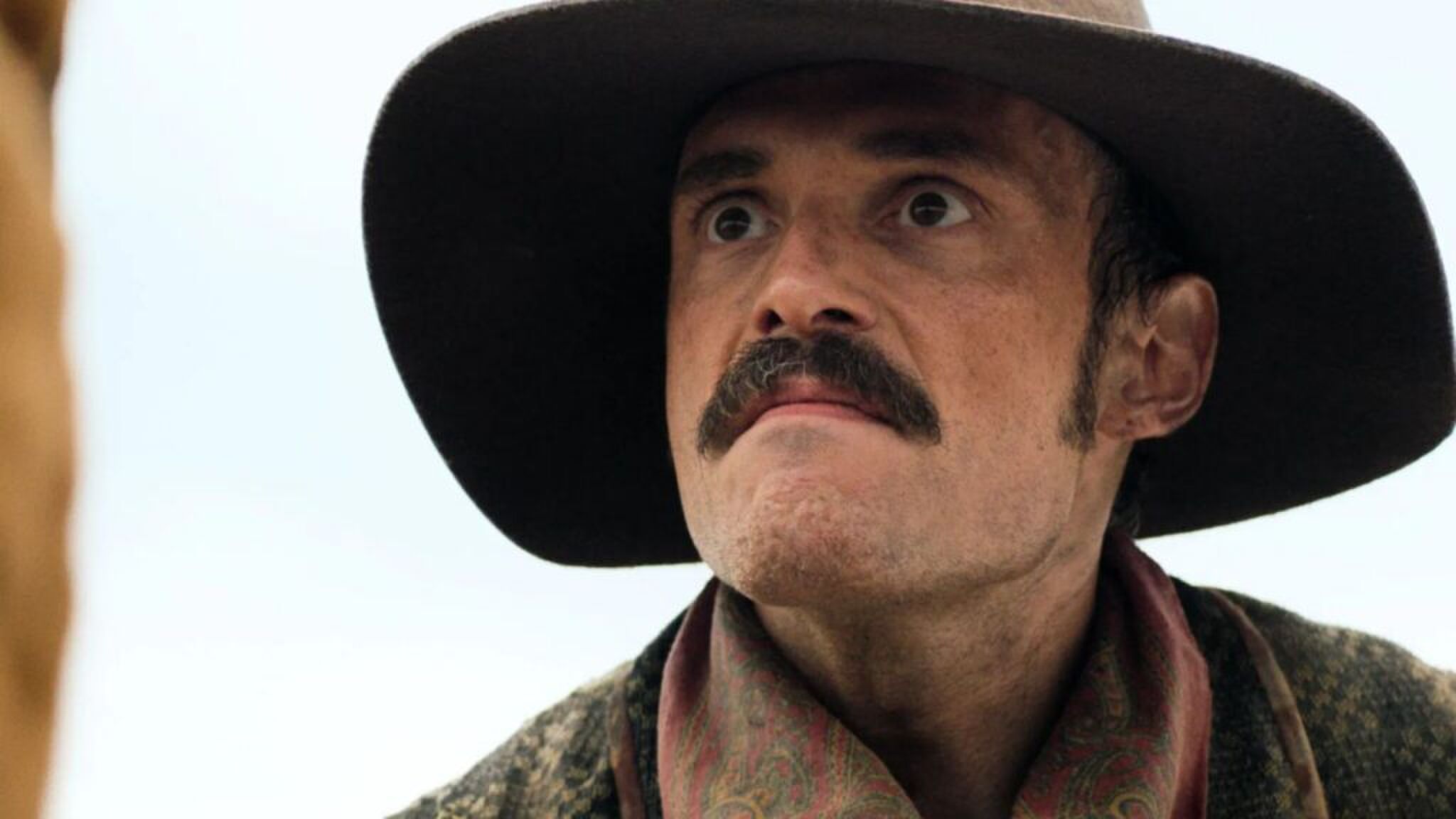 Een man met een hoed die omhoog kijkt