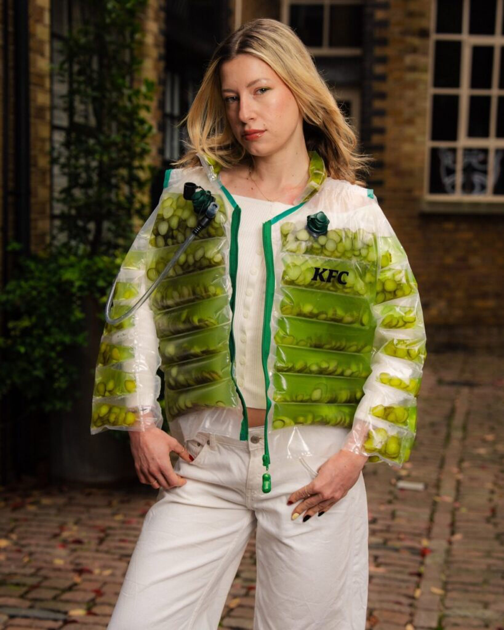 Een vrouw die een doorzichtige jas draagt, gevuld met augurken en augurkensap.