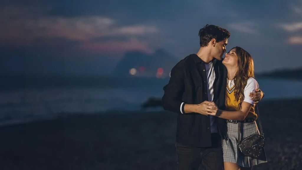 Een man en vrouw die elkaar vasthouden op het strand.