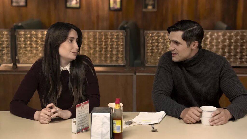 Een man en vrouw die aan een bar zitten in een restaurant. 