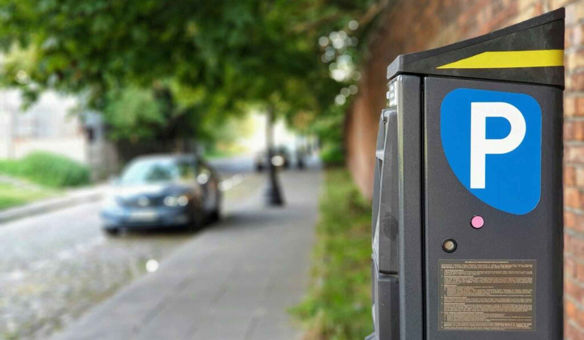 Een parkeerautomaat langs een straat.
