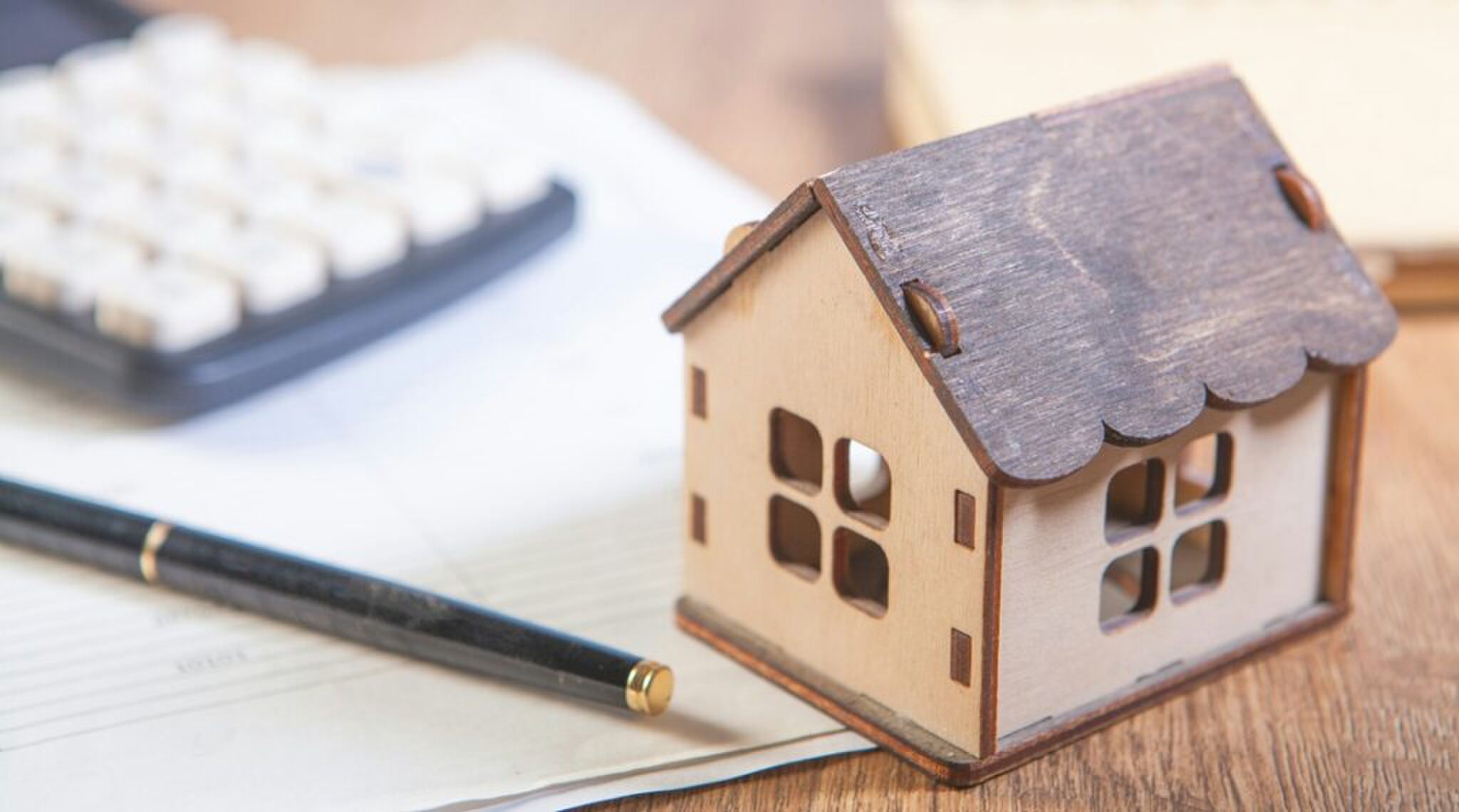 Een klein huisje naast een rekenmachine.