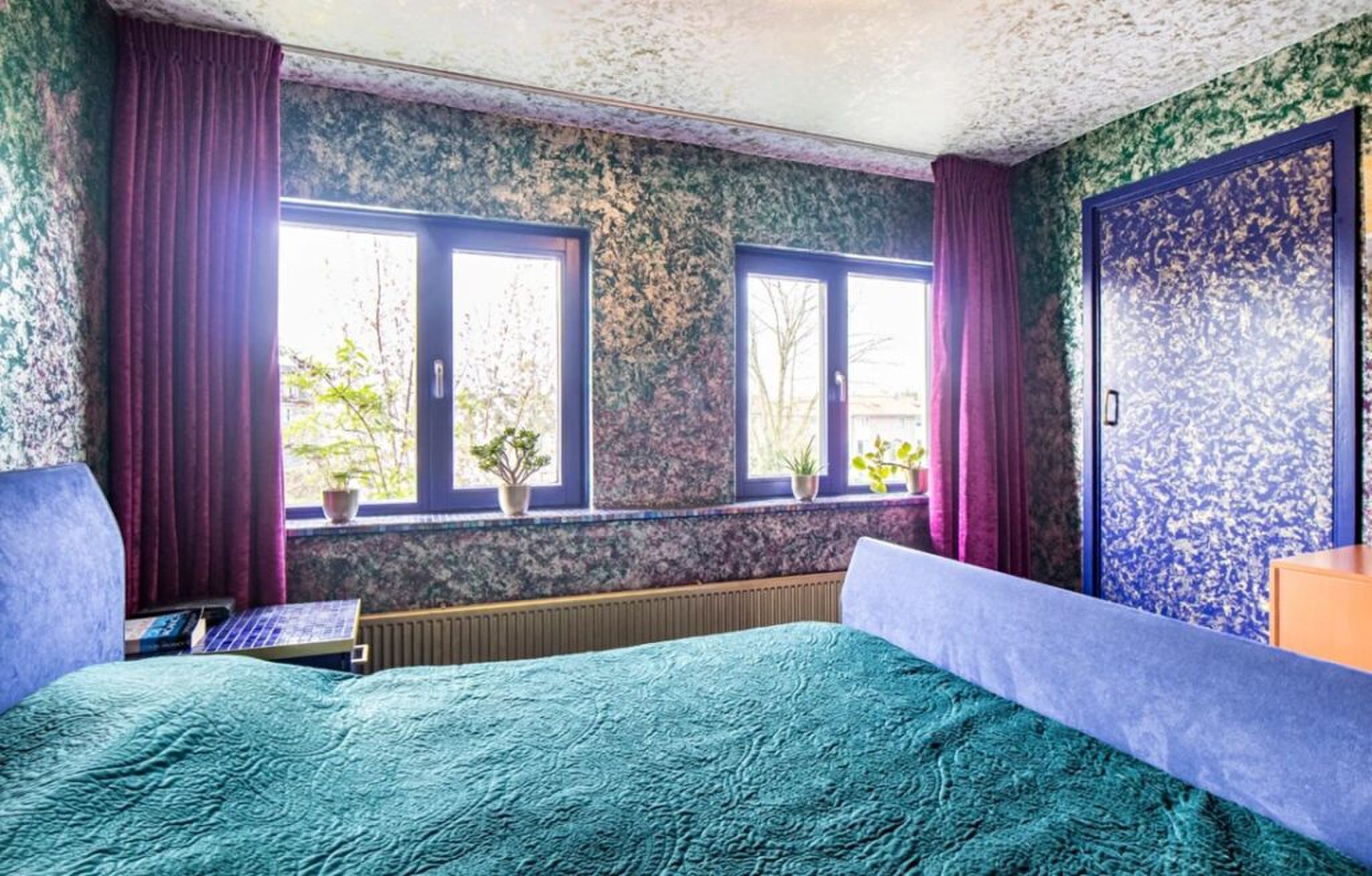 De slaapkamer met opvallend behang.