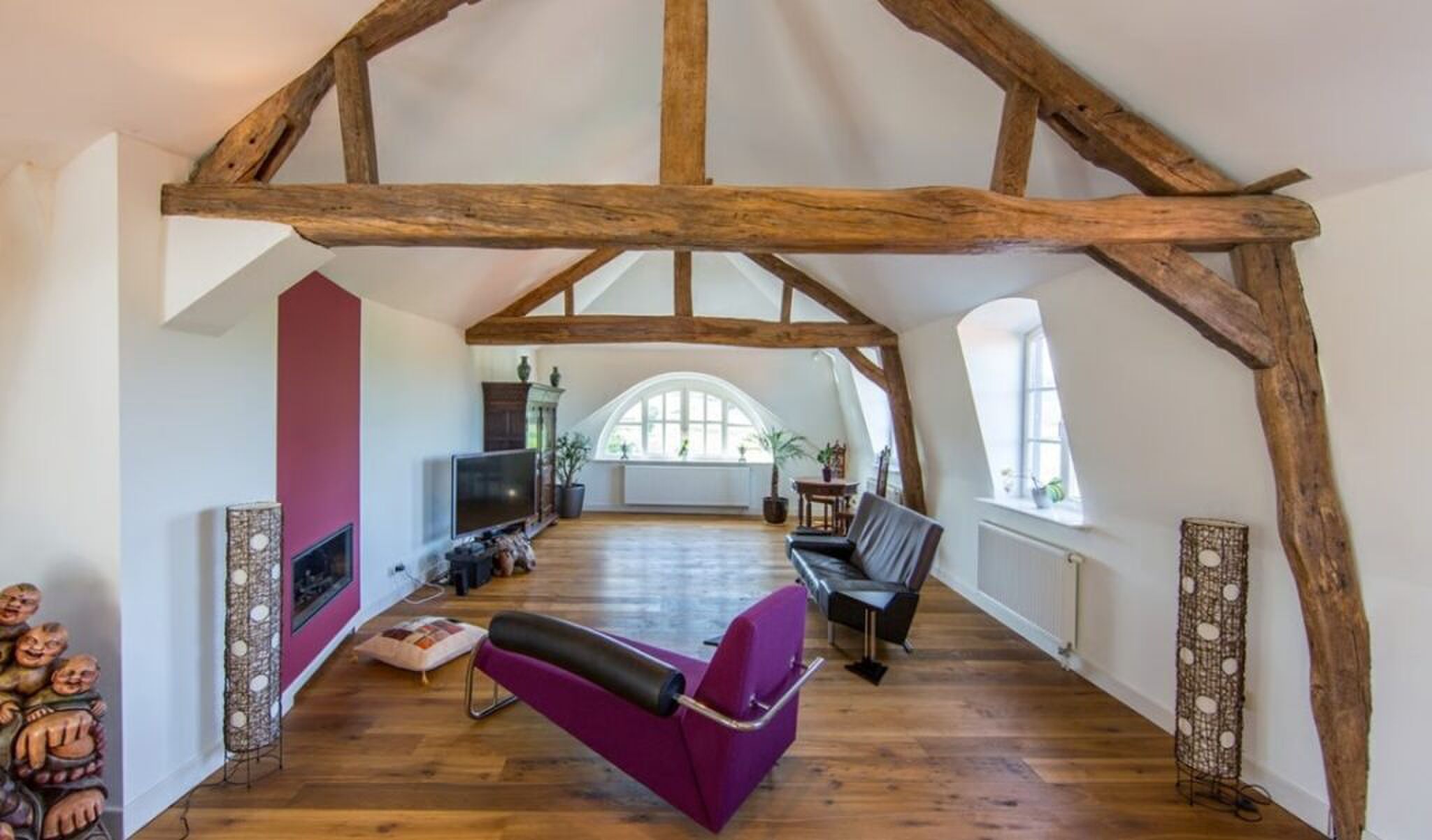 De living met houten balken aan het plafond.