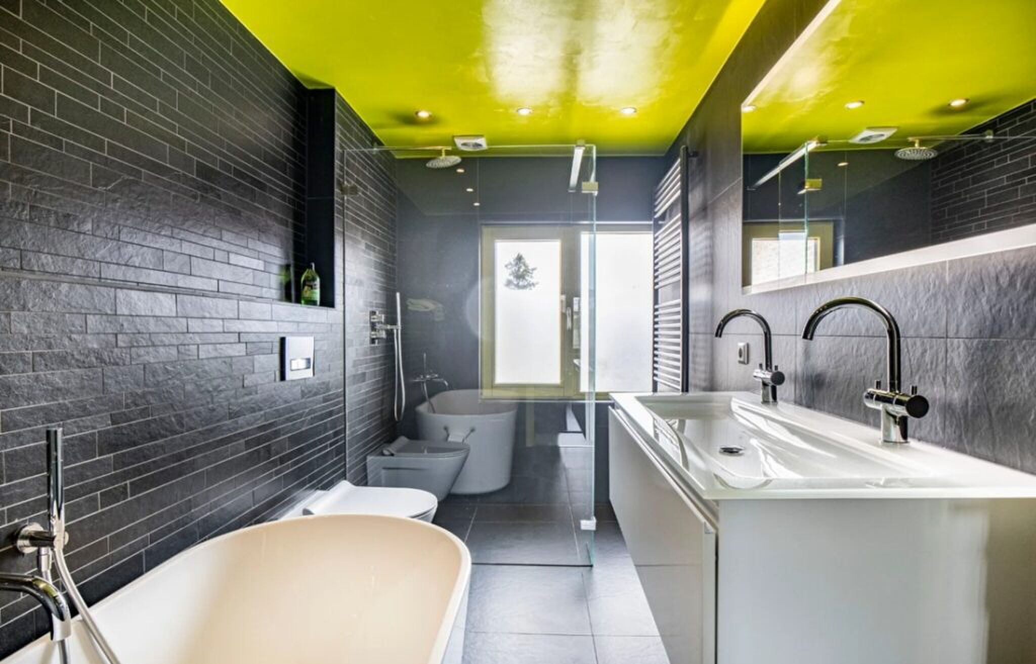 De badkamer met geel plafond.