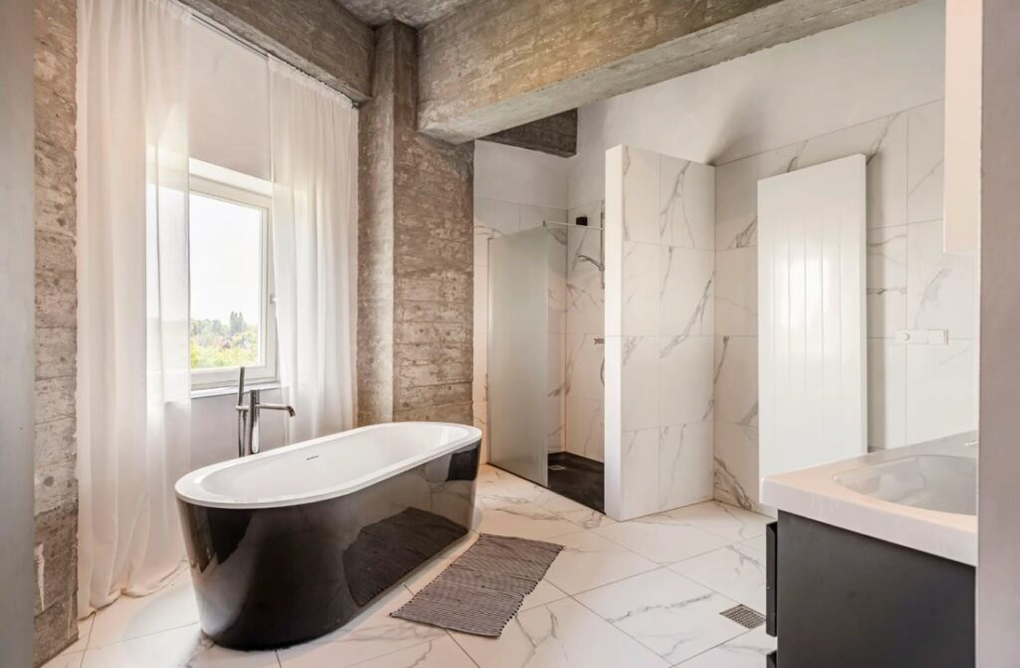 De badkamer met ligbad.