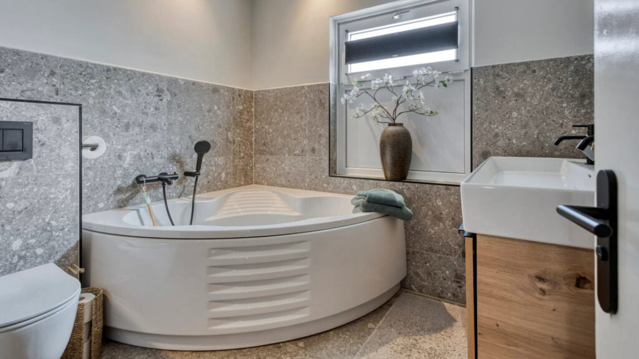 De badkamer met ligbad.