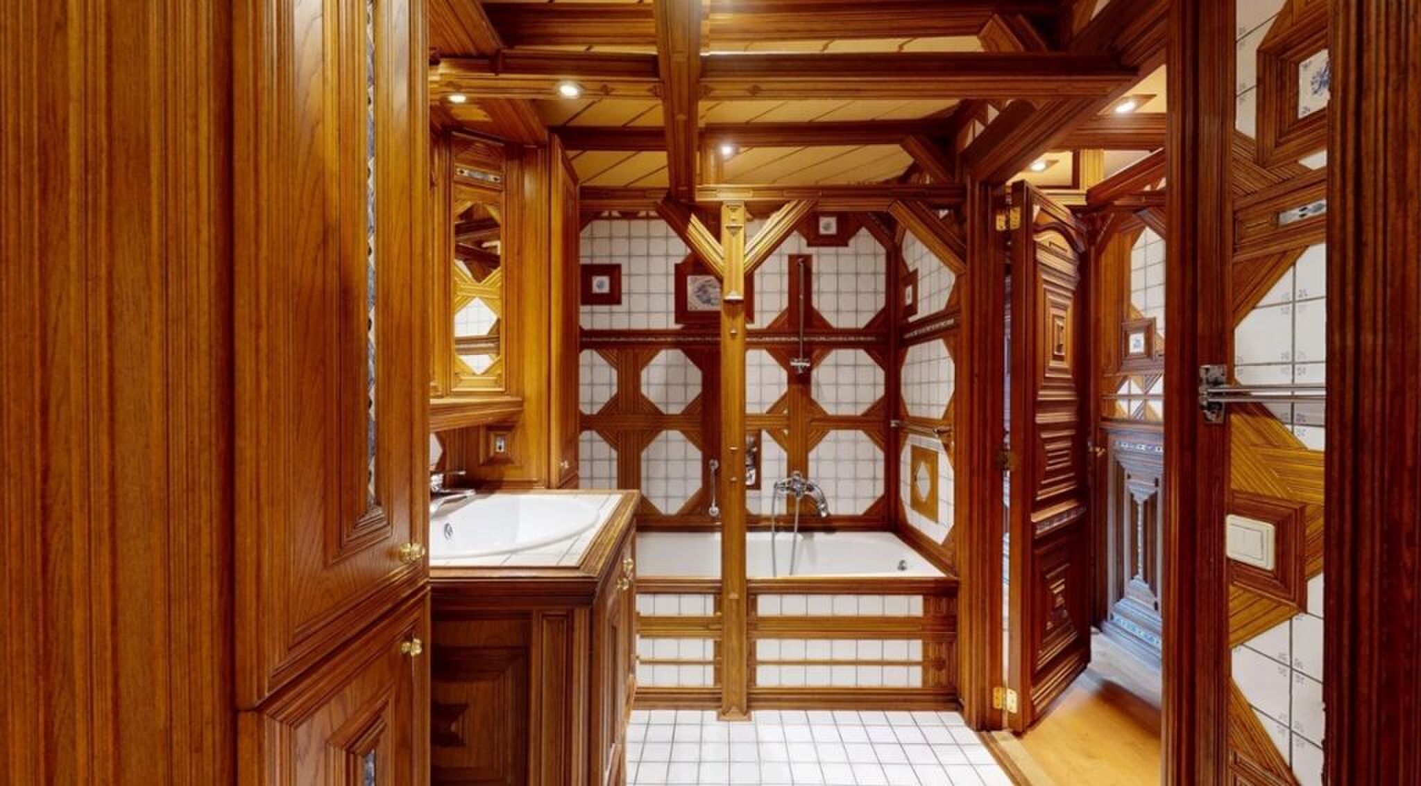 De houten badkamer met ligbad.