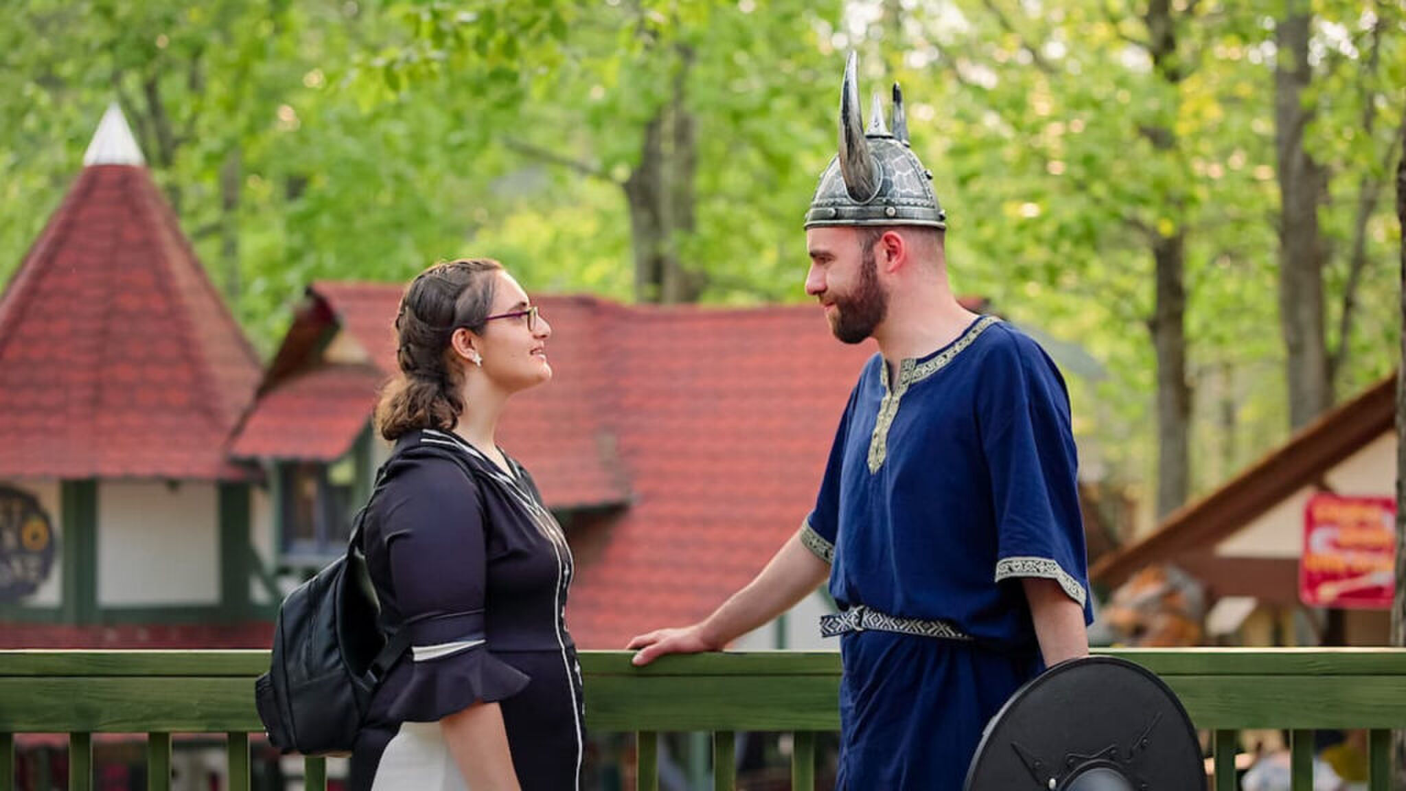 Een man en vrouw die tegenover elkaar staan en de man is verkleed als Viking. 
