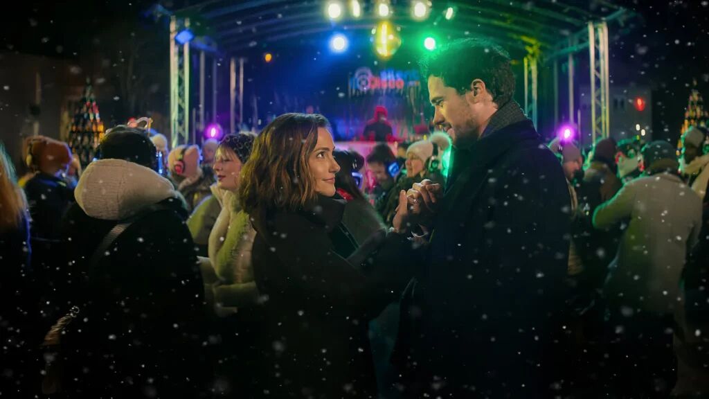 Een man en vrouw die op een feestje staan en een pinky swear doen. 