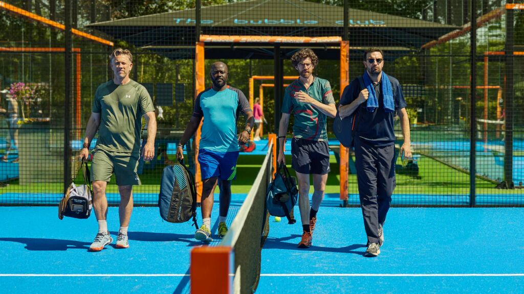 Vier mannen op een tennisveld in de serie Haantjes