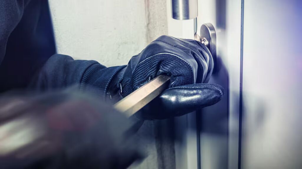 een inbreker forceert een deur open