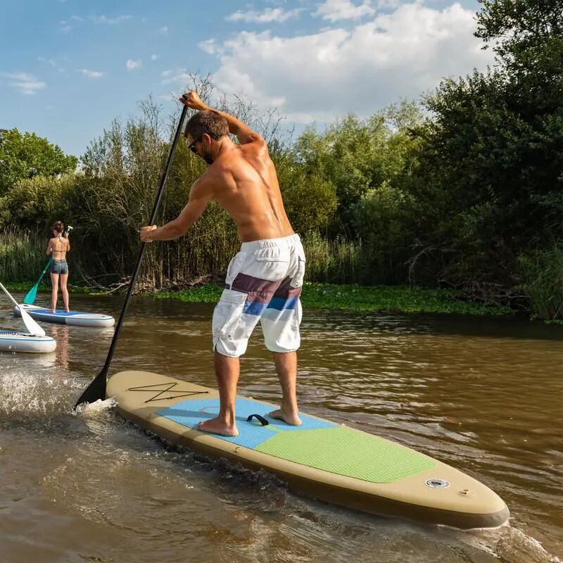 Man die heerlijk staat te peddelen op een supboard in het zonnetje.