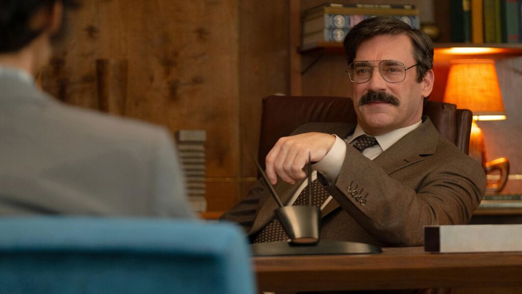 Een man die zit achter een bureau in de film 'The 33' 