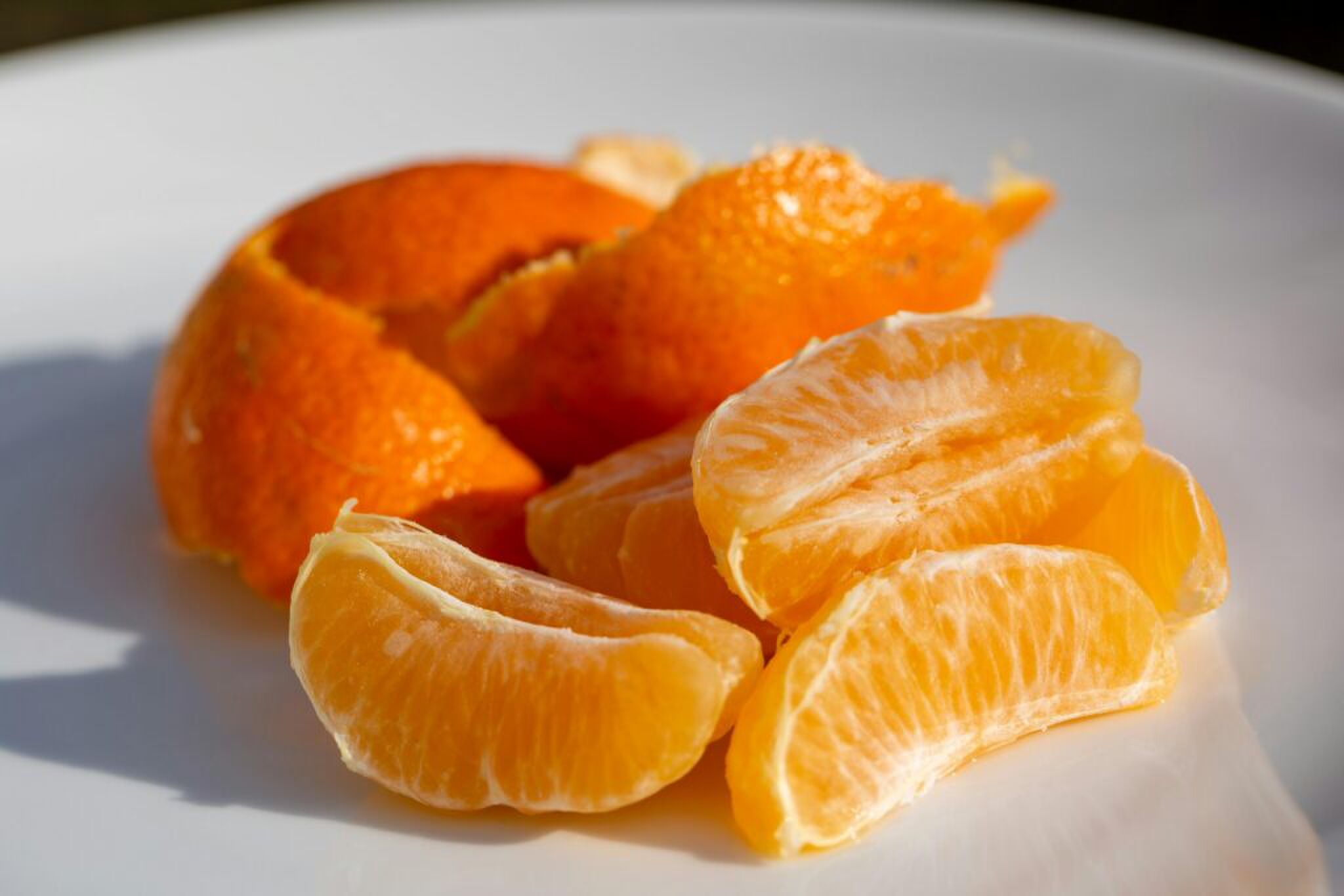 Een gepelde mandarijn met de schil erachter. 