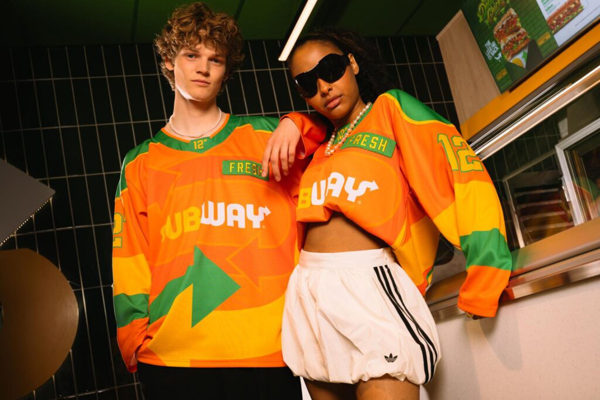 Mensen die het oranje koningsdag ijshockeyshirt van Subway dragen