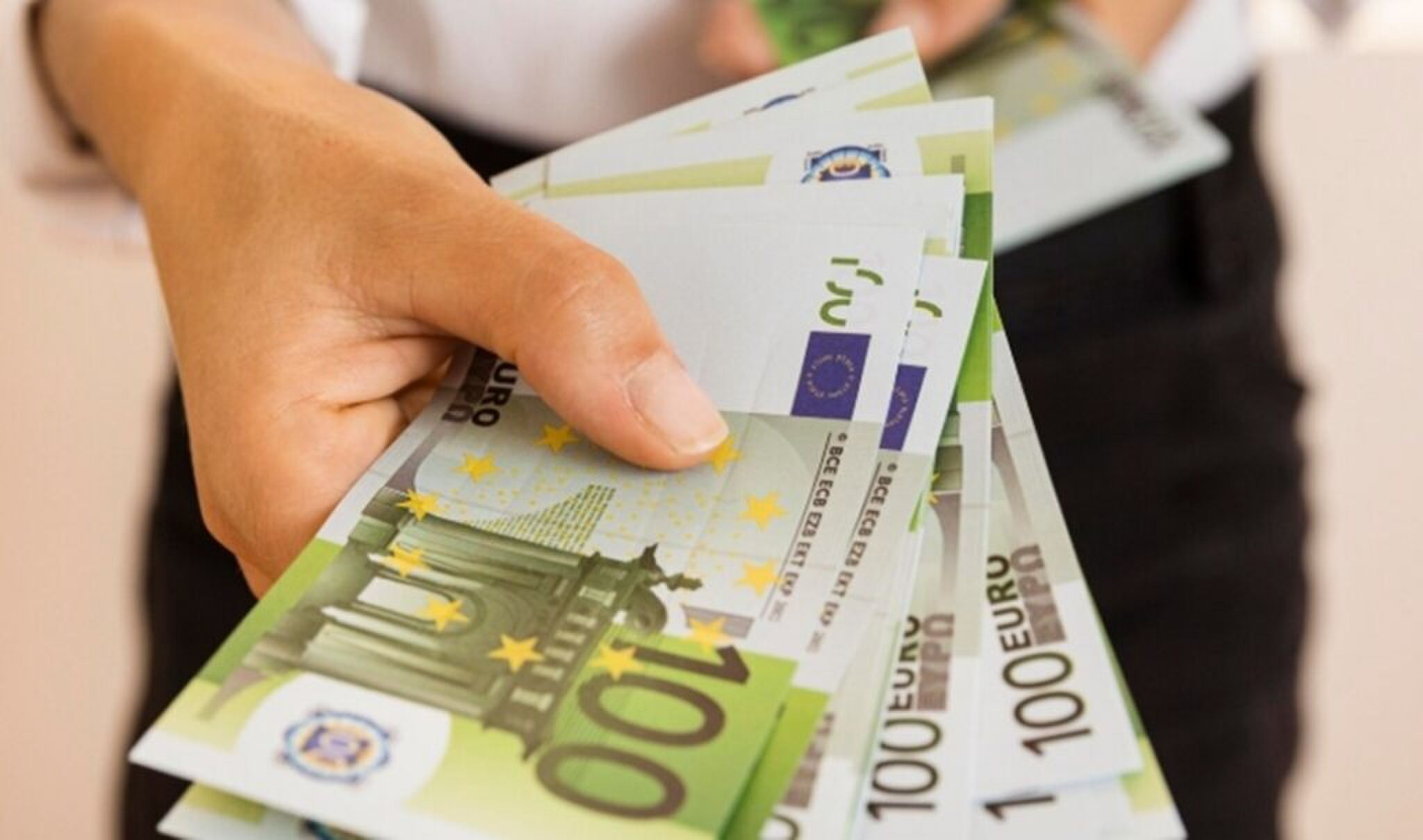 Persoon die cashgeld overhandigd.