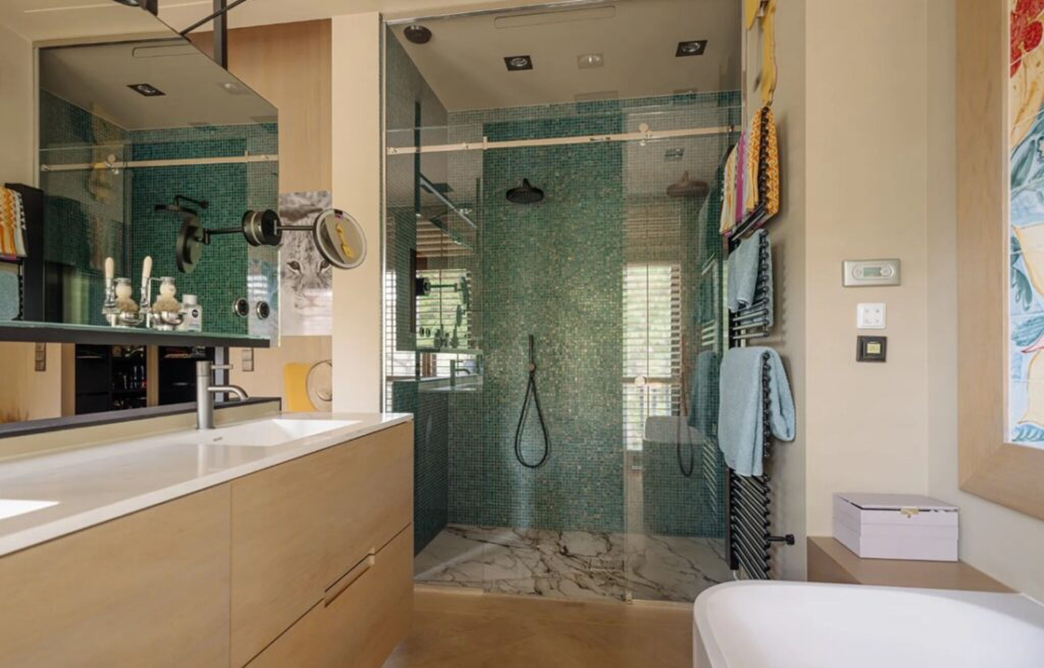 De badkamer met ligbad en dubbele inloopdouche.