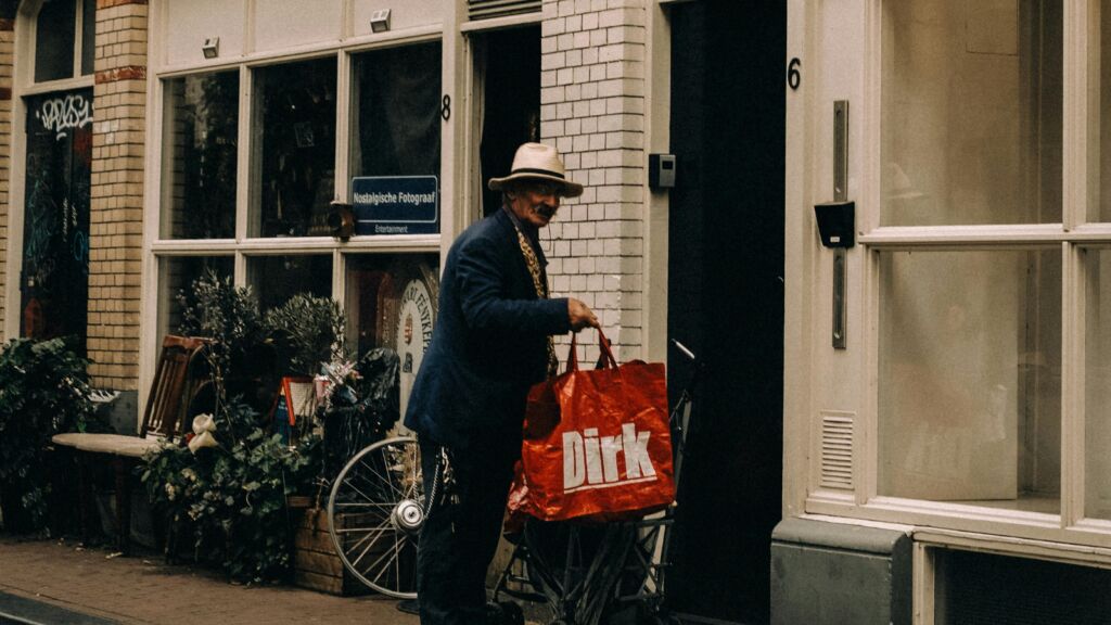 Een man die met een boodschappentas buiten staat. 