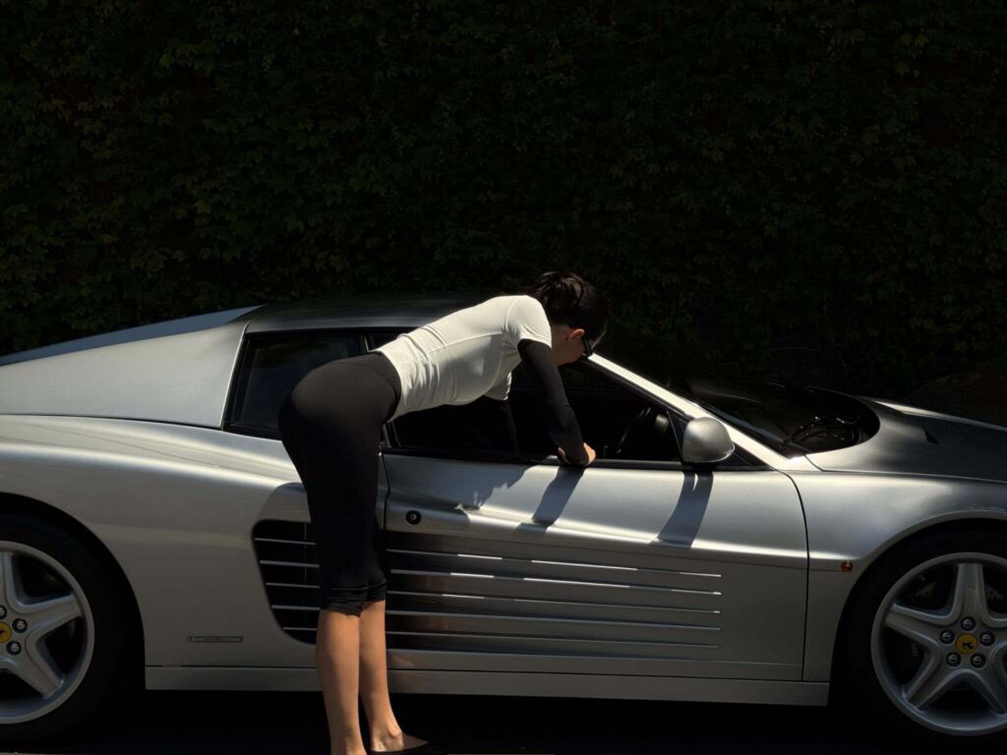 Een meisje dat wat uit haar auto pakt via het raam. 