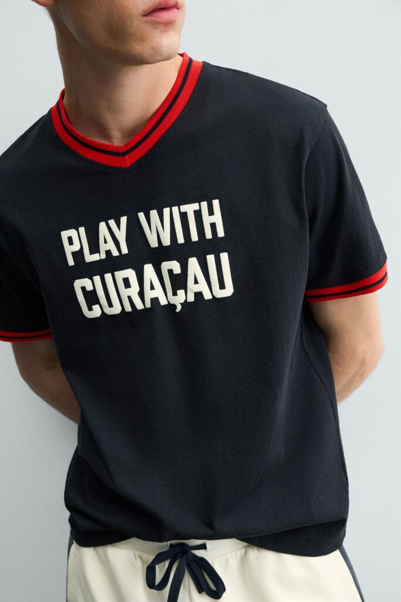 Een zwart shirt van de Zara met Curaçau erop.