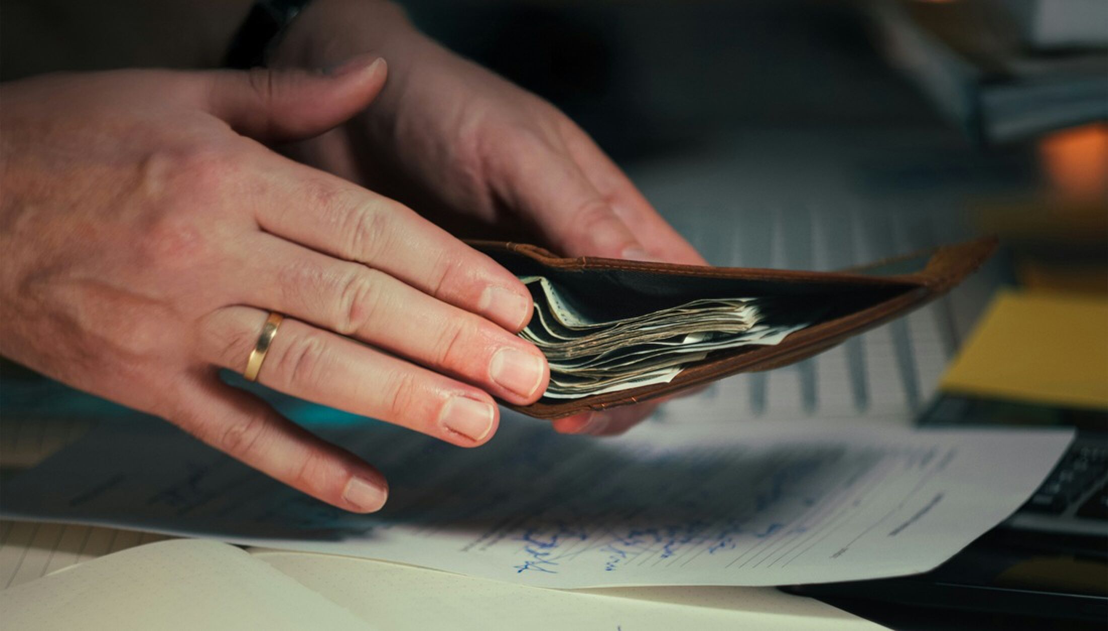 Man die geld in een portemonnee stopt.