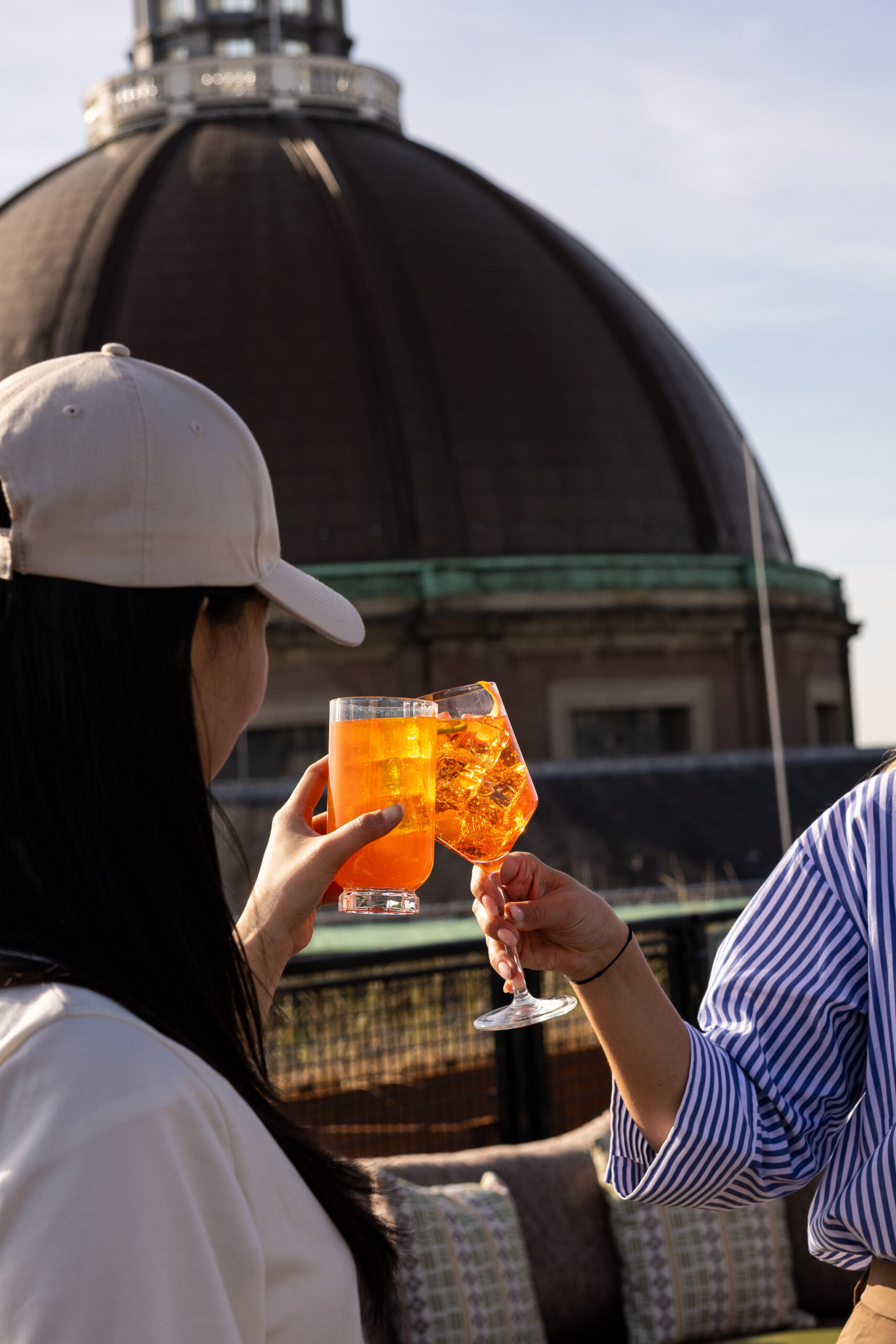 Mensen die genieten van een cocktail op het buitenterras van CIMA