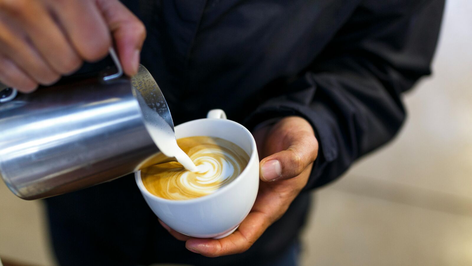 Iemand die een kopje koffie maakt.